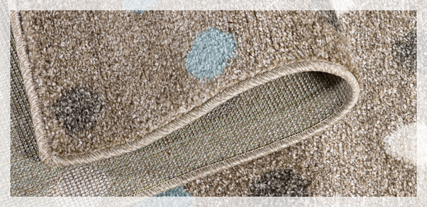 Dywan w odcieniach beżu w białe i błękitne kropki z widocznymi efektami prania ekstarkcyjnego.